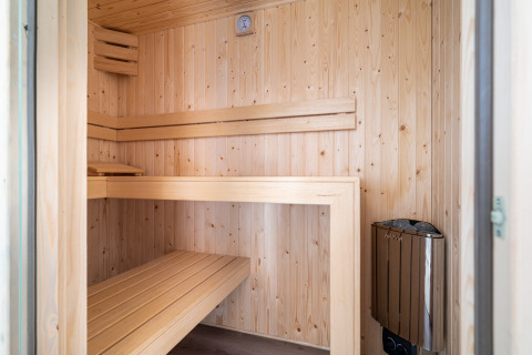 Interior de una sauna moderna con paneles de madera clara en Knilles Luxe, Tusken de Marren, Países Bajos.