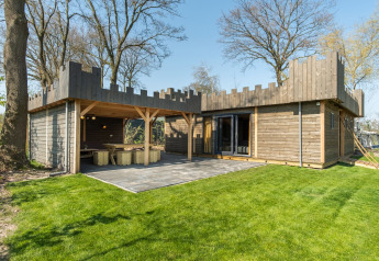 Lodge moderno in legno con design da castello, patio e prato presso Kampeerdorp de Zandstuve, Paesi Bassi.