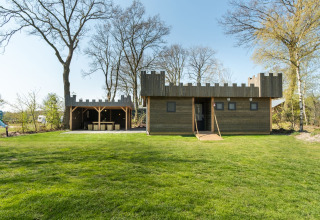 A wooden lodge designed like a castle with battlements at Kampeerdorp de Zandstuve in the Netherlands.