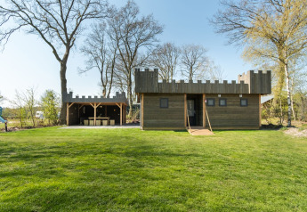 Un lodge in legno a forma di castello con merli a Kampeerdorp de Zandstuve nei Paesi Bassi.