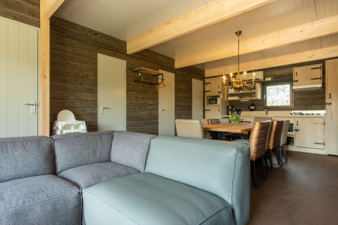 Woonkamer en keuken in een houten lodge bij Castle Uylenburght, Kampeerdorp de Zandstuve, Nederland.