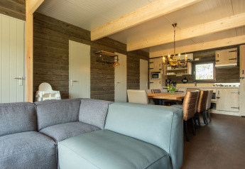 Wohnzimmer und Küche in einer Holzhütte im Castle Uylenburght, Kampeerdorp de Zandstuve, Niederlande.