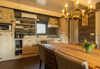 Cucina accogliente e zona pranzo in un lodge di Castle Uylenburght, Kampeerdorp de Zandstuve, Paesi Bassi.