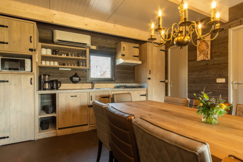 Acogedora cocina y comedor en una cabaña de Castle Uylenburght, Kampeerdorp de Zandstuve, Países Bajos.