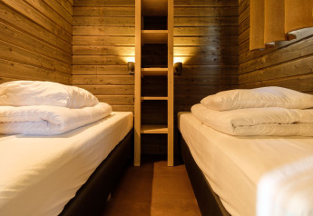 Cozy wood-paneled twin bedroom at Castle Uylenburght lodge in Kampeerdorp de Zandstuve, the Netherlands.