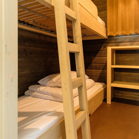 Cozy lodge room with wooden bunk beds and shelving at Castle Uylenburght, Kampeerdorp de Zandstuve, Netherlands.