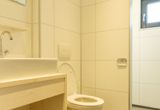 Moderne badkamer bij Castle Uylenburght, Kampeerdorp de Zandstuve, Nederland, met toilet en wastafel.