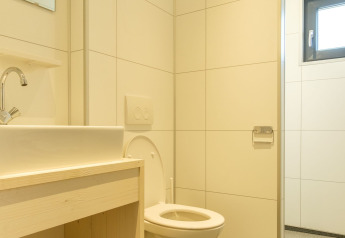 Moderne badkamer bij Castle Uylenburght, Kampeerdorp de Zandstuve, Nederland, met toilet en wastafel.