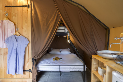 Interior de la tienda safari Staircase en Camping Valkenburg - Maastricht, con cama doble y literas.