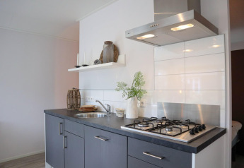 Cucina moderna al Wellness Lodge presso De Hooge Veluwe nei Paesi Bassi, con piano cottura a gas e cappa.