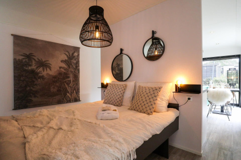 Dormitorio acogedor en Wellness Lodge en De Hooge Veluwe, Países Bajos, con decoración moderna y luz suave.