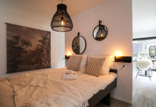 Dormitorio acogedor en Wellness Lodge en De Hooge Veluwe, Países Bajos, con decoración moderna y luz suave.