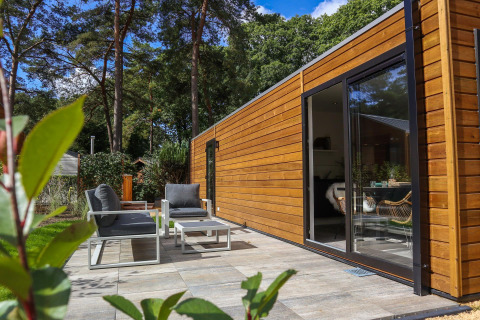 Patio esterno e cabina moderna in legno al Wellness Lodge di De Hooge Veluwe, Paesi Bassi, vista foresta.