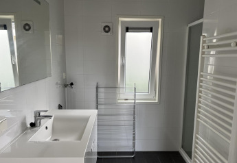 Badeværelse på L-Pavilion 6 ved De Achterhoek, Holland, med vask, bruser og vindue med matteret glas.