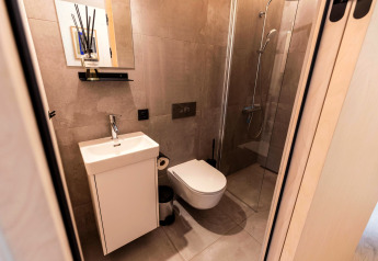 Salle de bain moderne et compacte avec douche et toilettes à Koya Tiny Cabin, Wilsumer Berge, Allemagne.