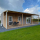 Modernes Cottage 4 mit überdachter Terrasse und Gartenansicht im Ferienpark De Biesbosch, Niederlande.
