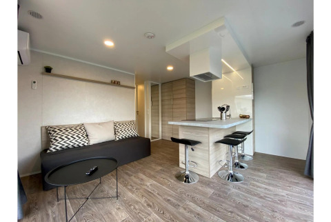 Moderne stue og køkken i Cottage 4 på De Biesbosch, Holland, med minimalistisk indretning og barstole.