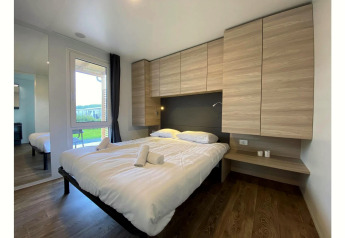 Modern bedroom in Cottage 4 at De Biesbosch, Netherlands, featuring a double bed and wood cabinets.