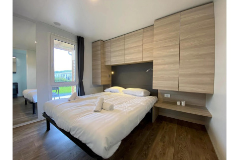 Modernes Schlafzimmer im Cottage 4 in De Biesbosch, Niederlande, mit Doppelbett und Holzschränken.