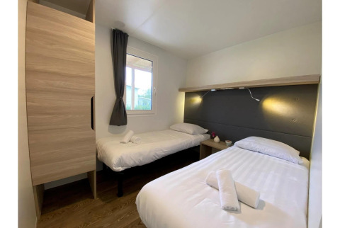 Dormitorio en Cottage 4 de De Biesbosch, Países Bajos, con dos camas individuales y decoración moderna.