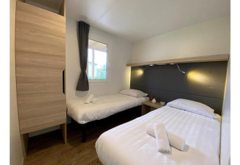 Dormitorio en Cottage 4 de De Biesbosch, Países Bajos, con dos camas individuales y decoración moderna.