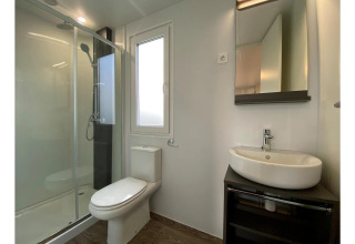 Baño moderno en Cottage 4 en De Biesbosch, Países Bajos, con ducha, inodoro, lavabo y espejo mural.