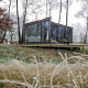 Moderne glasbeklædt hytte kaldet Cabin on the Hill ved Wilsumer Berge, omgivet af frostklædte træer.