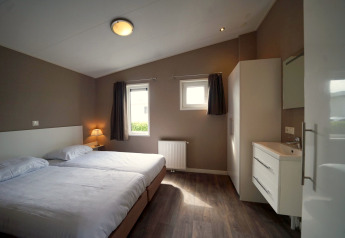 Dormitorio moderno con camas gemelas en L-Pavilion 6, De Biesbosch, Países Bajos, diseño contemporáneo.