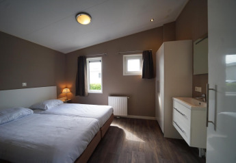 Slaapkamer met twee bedden in L-Pavilion 6, De Biesbosch, Nederland, met moderne en neutrale inrichting.