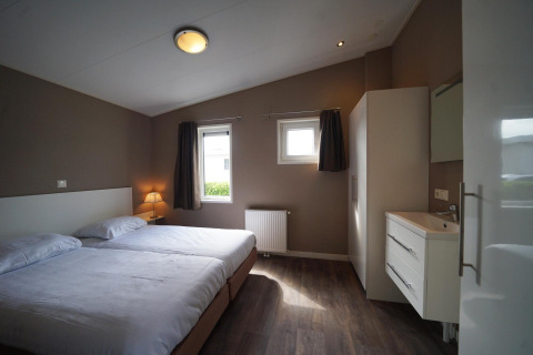 Dormitorio moderno con camas gemelas en L-Pavilion 6, De Biesbosch, Países Bajos, diseño contemporáneo.