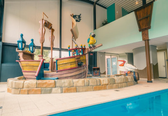 Binnenzwembad met piratenschip-speelstructuur in L-Pavilion 6 te De Biesbosch, Nederland.