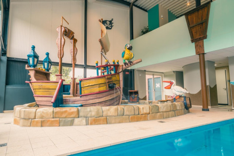 Zona de piscina interior con decoración de barco pirata en L-Pavilion 6, De Biesbosch, Países Bajos.