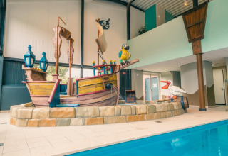 Zona de piscina interior con decoración de barco pirata en L-Pavilion 6, De Biesbosch, Países Bajos.