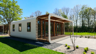 Lodge moderne avec grandes fenêtres et éléments bois au Marina Strandbad, Pays-Bas, par beau temps.
