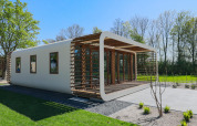 Moderno lodge con grandes ventanales y detalles de madera en Marina Strandbad, Países Bajos, en primavera.