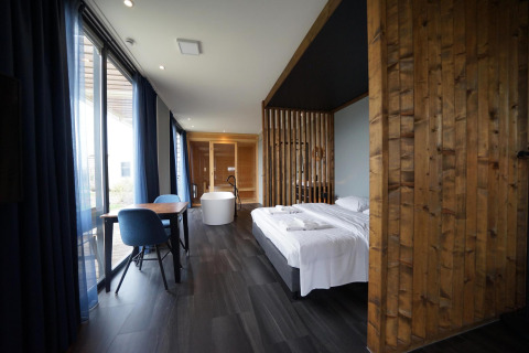 Modernes Lodge-Zimmer Mode Wellness 2 im Marina Strandbad, Niederlande, mit Holzdekor und Badewanne.