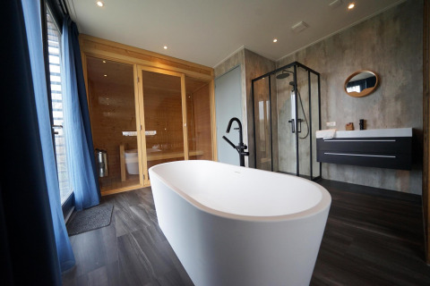 Baño moderno con bañera independiente, sauna y ducha en Mode Wellness 2, Marina Strandbad, Países Bajos.