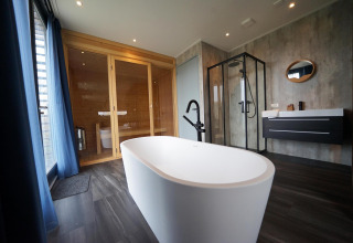 Bagno moderno con vasca indipendente, sauna e doccia al Mode Wellness 2 presso Marina Strandbad, Paesi Bassi.