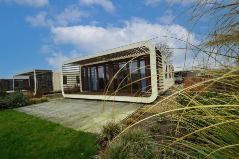 Lodge moderne Mode Wellness 2 à Marina Strandbad aux Pays-Bas, terrasse et nature sous ciel bleu.