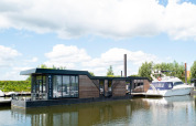 Casa flotante Water lodge 4 en Marina Strandbad, Países Bajos, diseño contemporáneo sobre el agua.