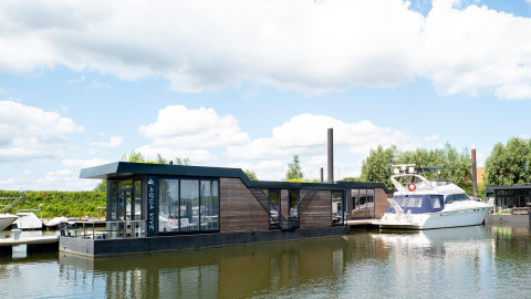 Woonboot Water lodge 4 bij Marina Strandbad in Nederland, moderne drijvende woning met grote ramen.