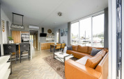 Modernes Wohnzimmer auf dem Hausboot Water Lodge 4 bei Marina Strandbad, Niederlande, mit Ledersofa.