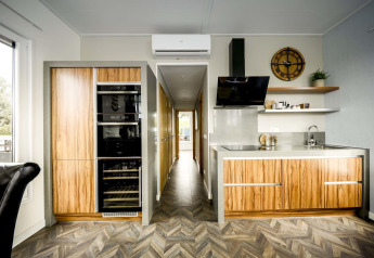 Moderne keuken op het woonboot Water lodge 4 bij Marina Strandbad in Nederland, met houten afwerking.