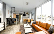 Moderne stue på en husbåd, Water lodge 4 ved Marina Strandbad, Holland, med store vinduer og lædersofa.