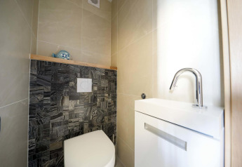 Moderne toilet og håndvask på husbåd Water Lodge 4 ved Marina Strandbad i Holland, lyst og stilrent.