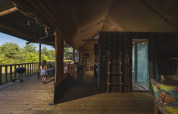 Tienda safari en Wilsumer Berge, Alemania, con terraza de madera, vista interior y una niña afuera.