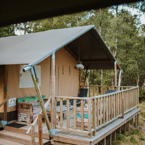 Safari-Zelt mit Holzterrasse und Sitzgelegenheiten im Grünen auf Wilsumer Berge in Deutschland.
