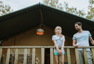 Un uomo e una ragazza sono sul balcone di una tenda safari a Wilsumer Berge in Germania.