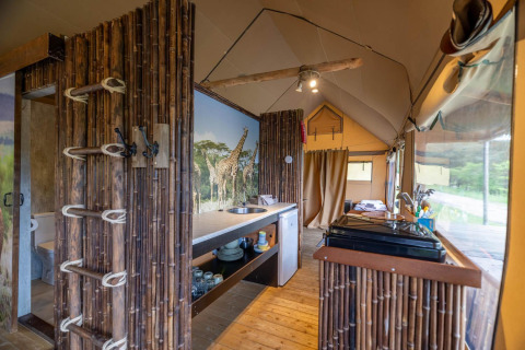 Interior de una tienda safari en Wilsumer Berge, Alemania, con decoración de bambú y mural de jirafas.