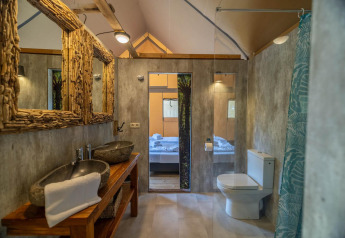 Baño moderno en tienda safari en Wilsumer Berge, Alemania, con lavabos de piedra y espejos rústicos.